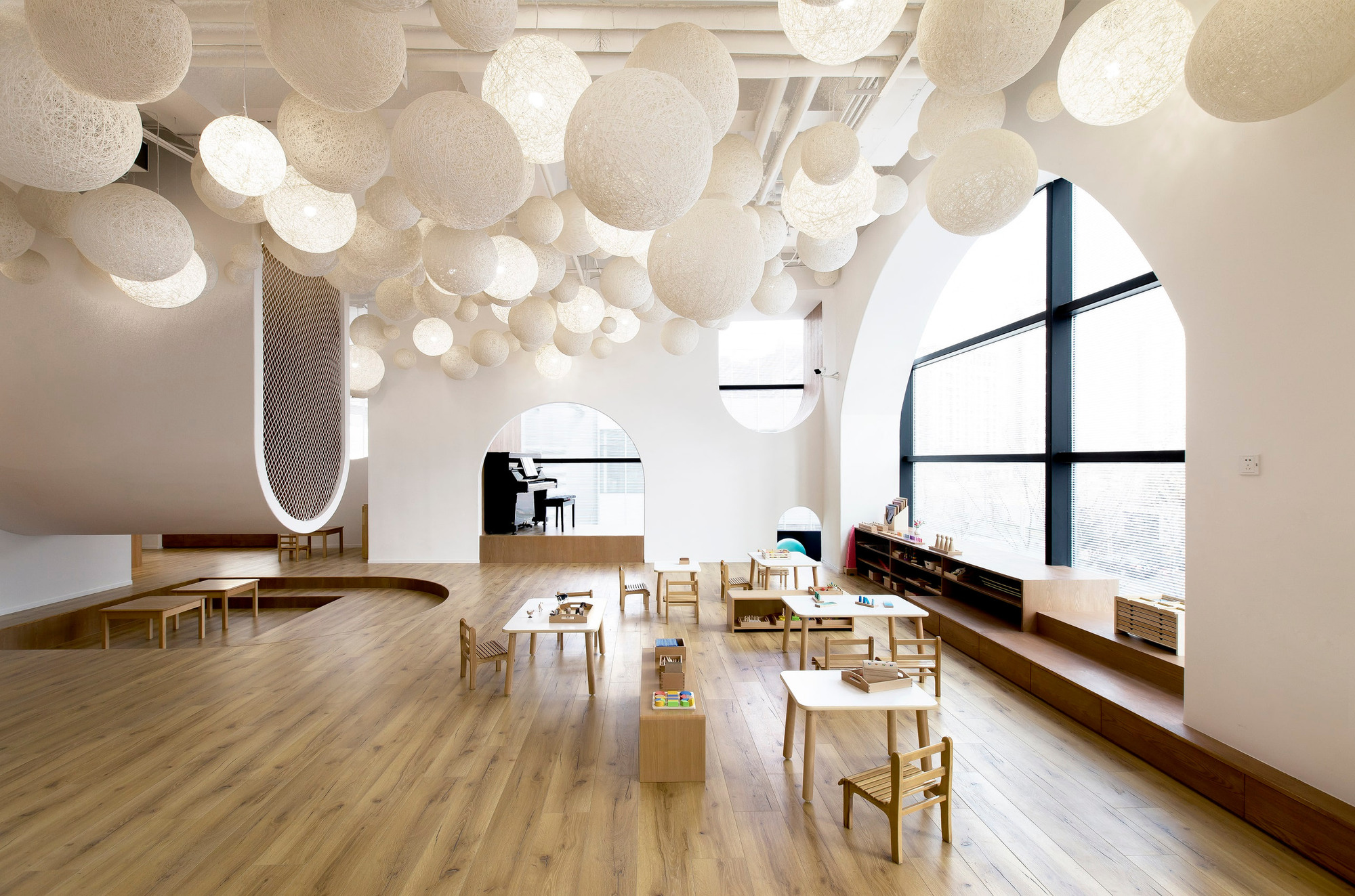 Completed learning room with shared tables, integrated seating and suspended ceiling elements.