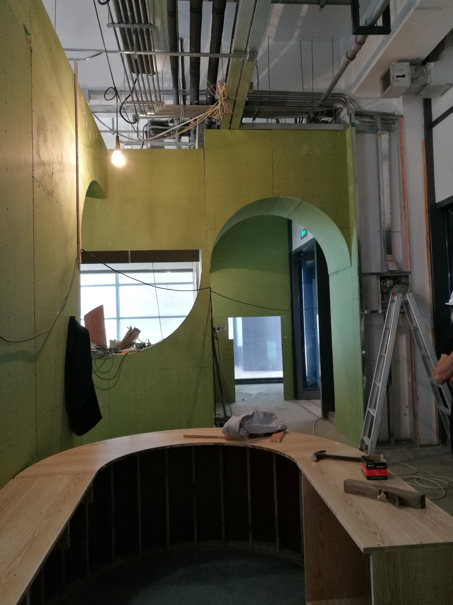 Reception during construction, before the timber finishes and completed curved desk.
