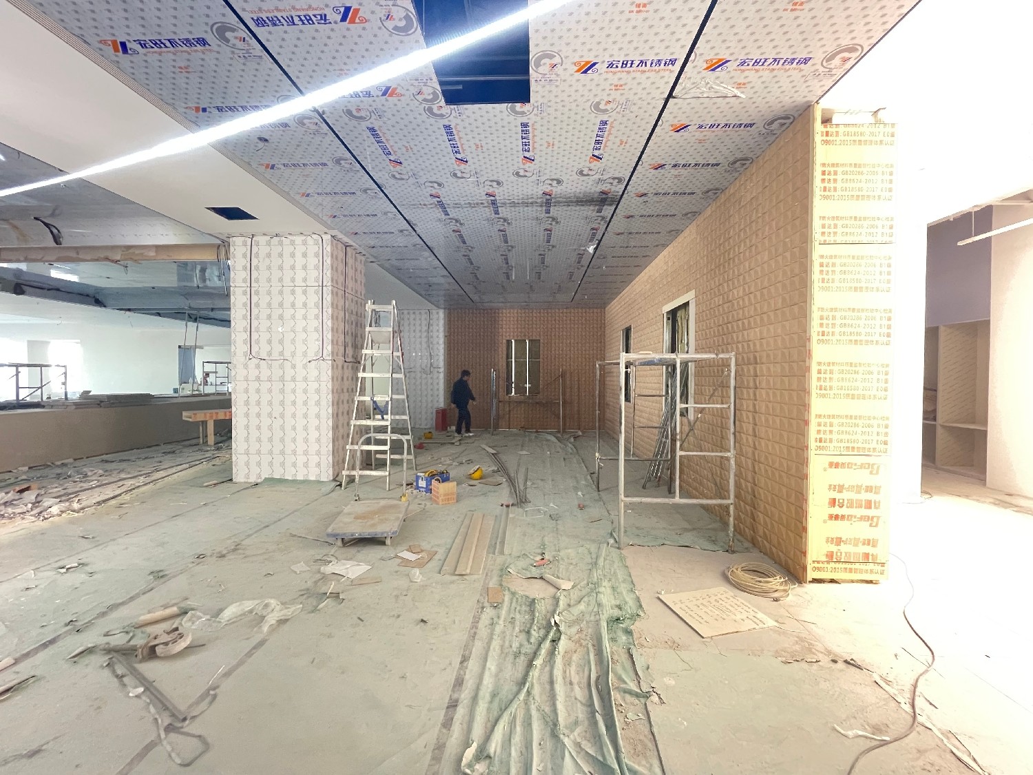 Ceiling installation and the vertical wall finish during construction.