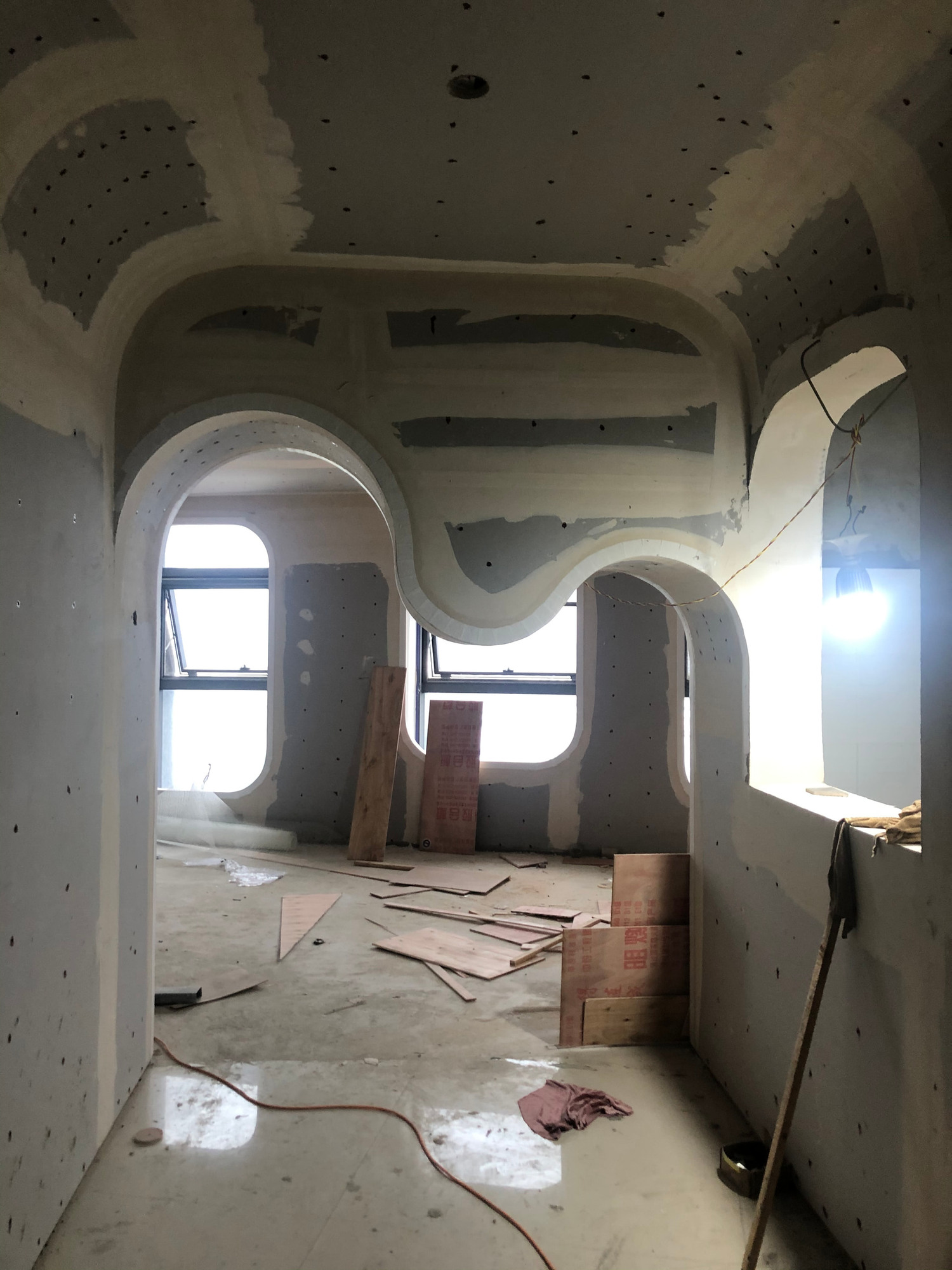 The curved threshold during construction, with unfinished surfaces and exposed services.